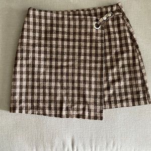 Brown plaid back zip mini skirt with a symmetrical front flap.